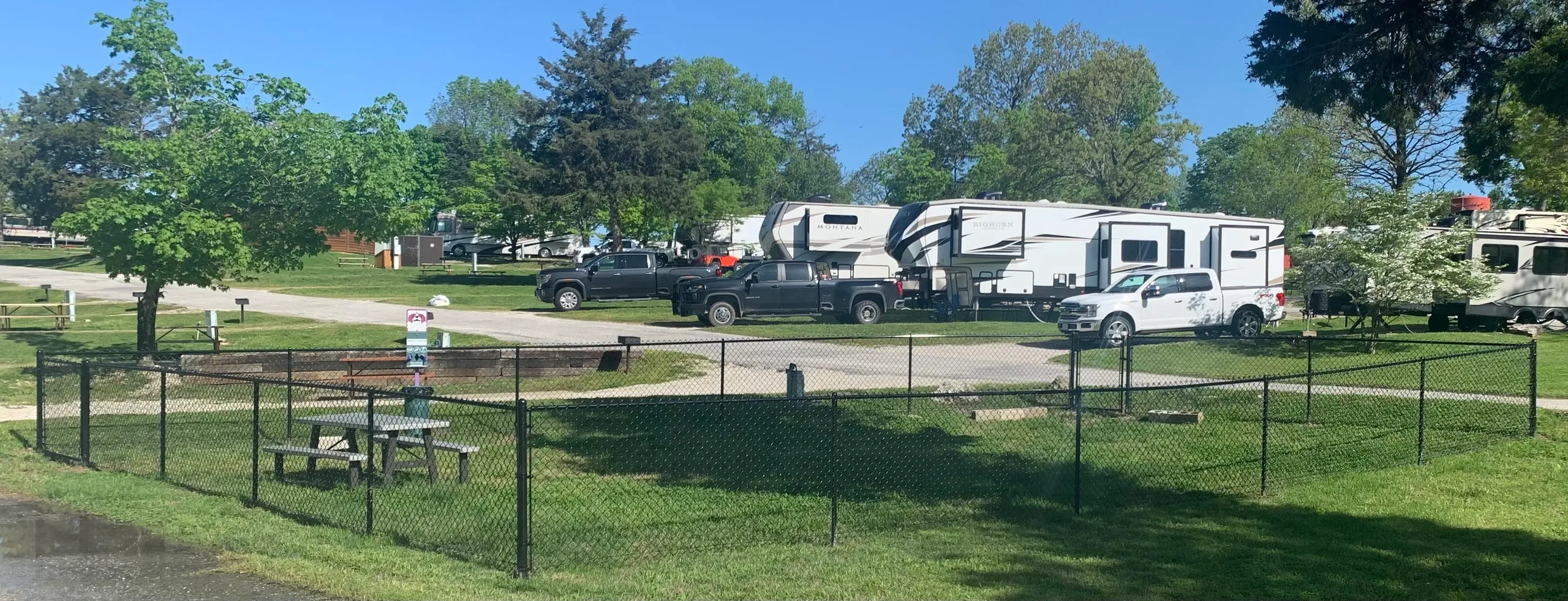 A white truck is parked in a lot with other trucks