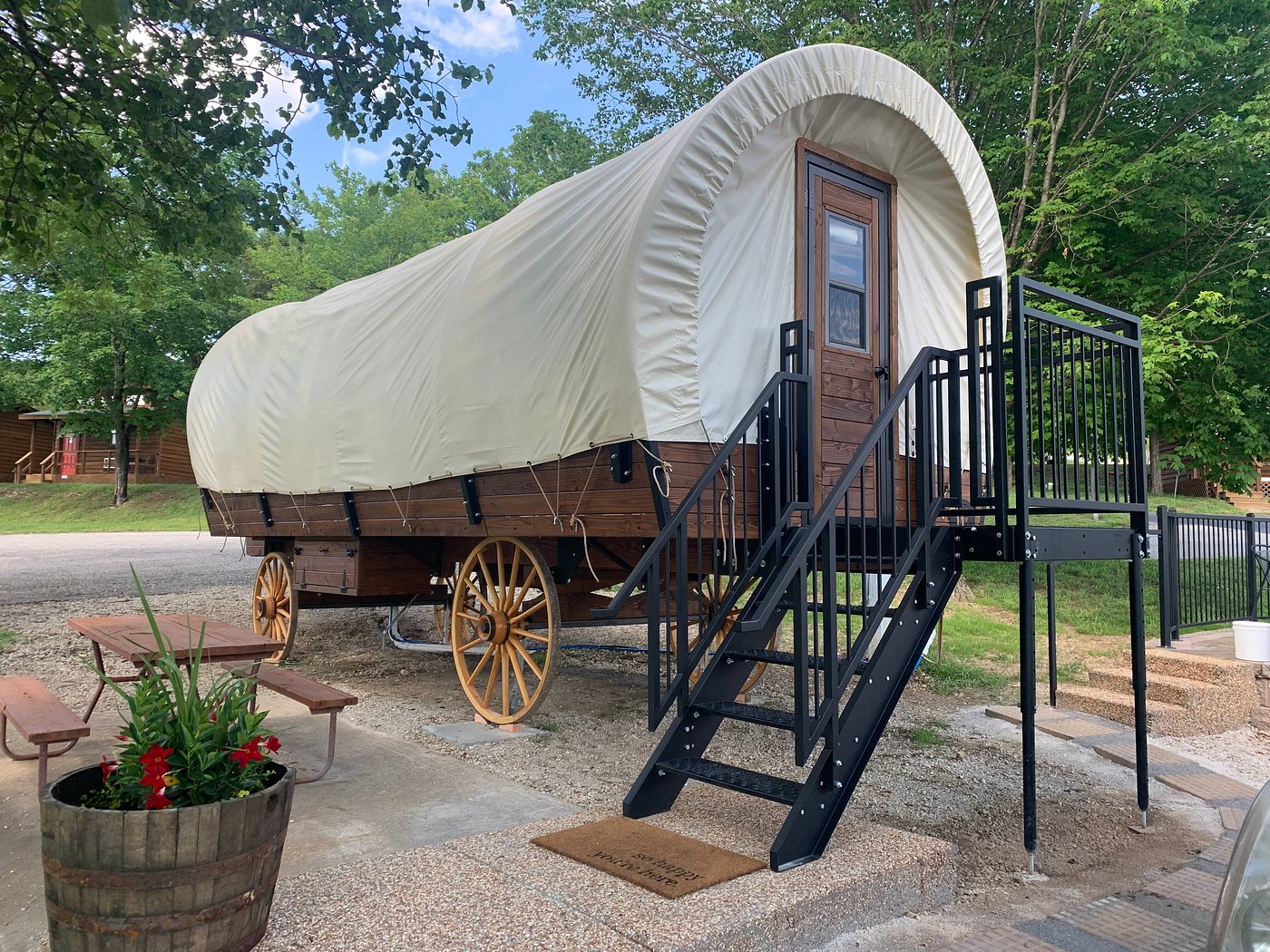 A large, old-fashioned wagon is parked on a gravel driveway