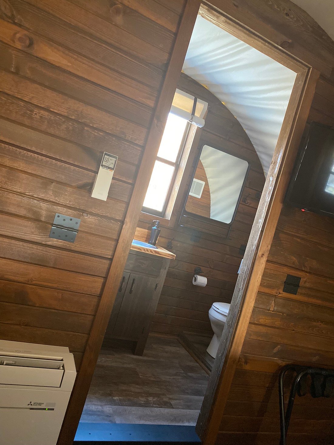 A white toilet with a wooden door