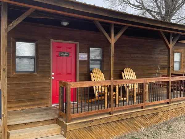 A red door on a cabin with a sign on it